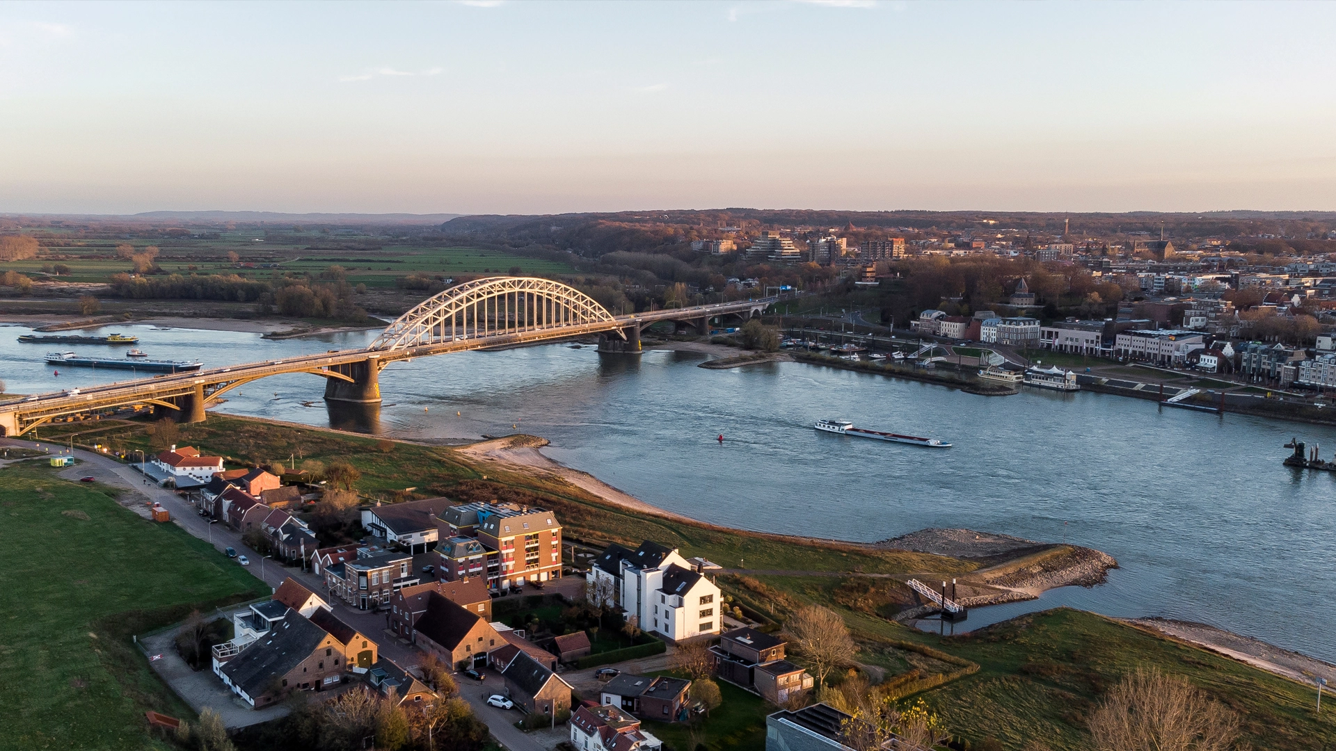 Een grote brug, met op allebei kanten een stukje van een stad te zien